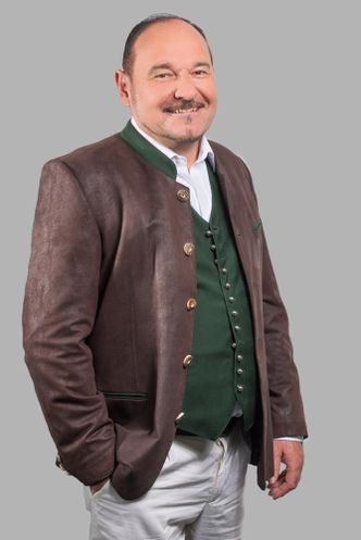 Porträtfoto von Mag. Andreas Vogl mit grauem Hintergrund